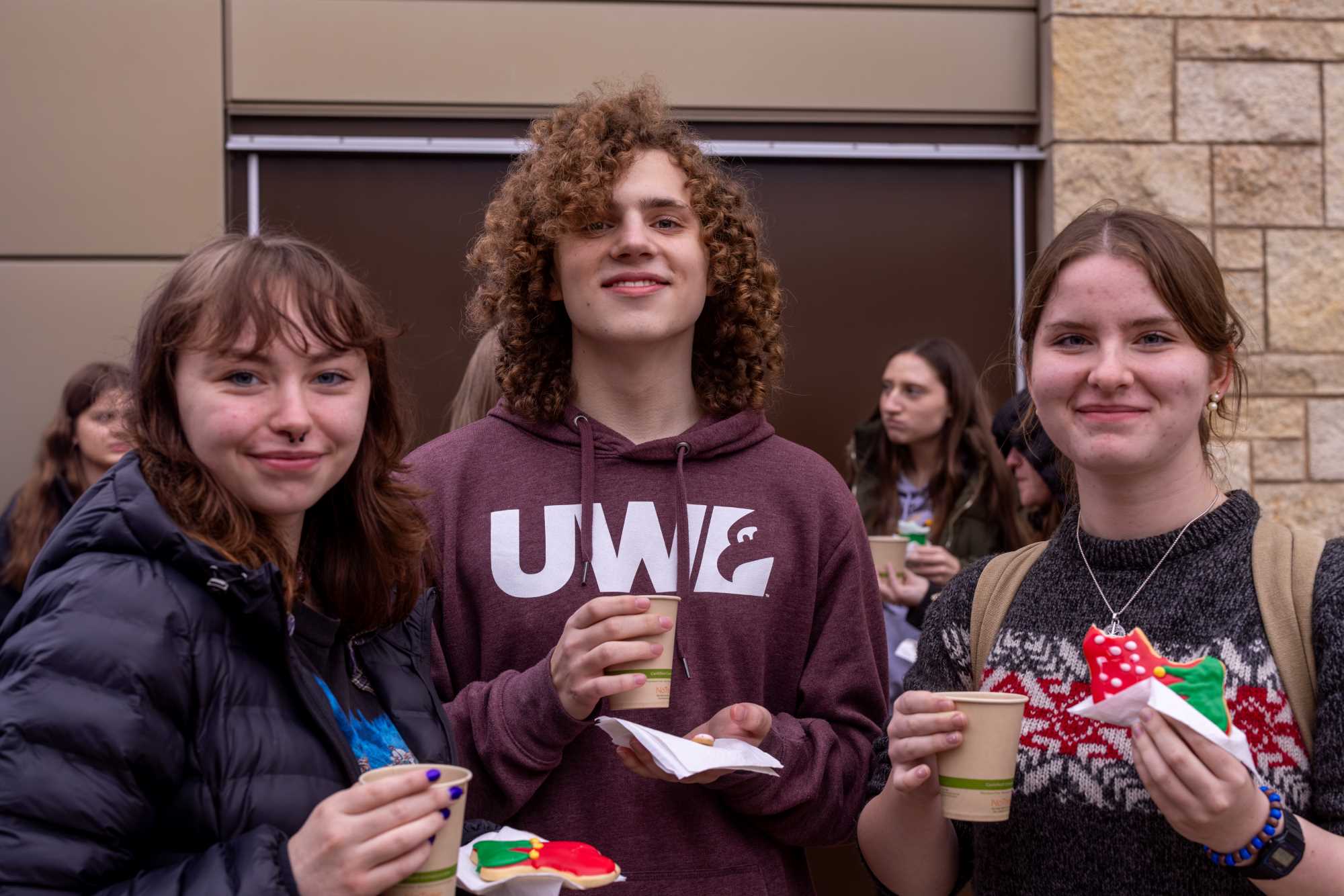 Three students waiting for the Campus Holiday Tree Lighting.