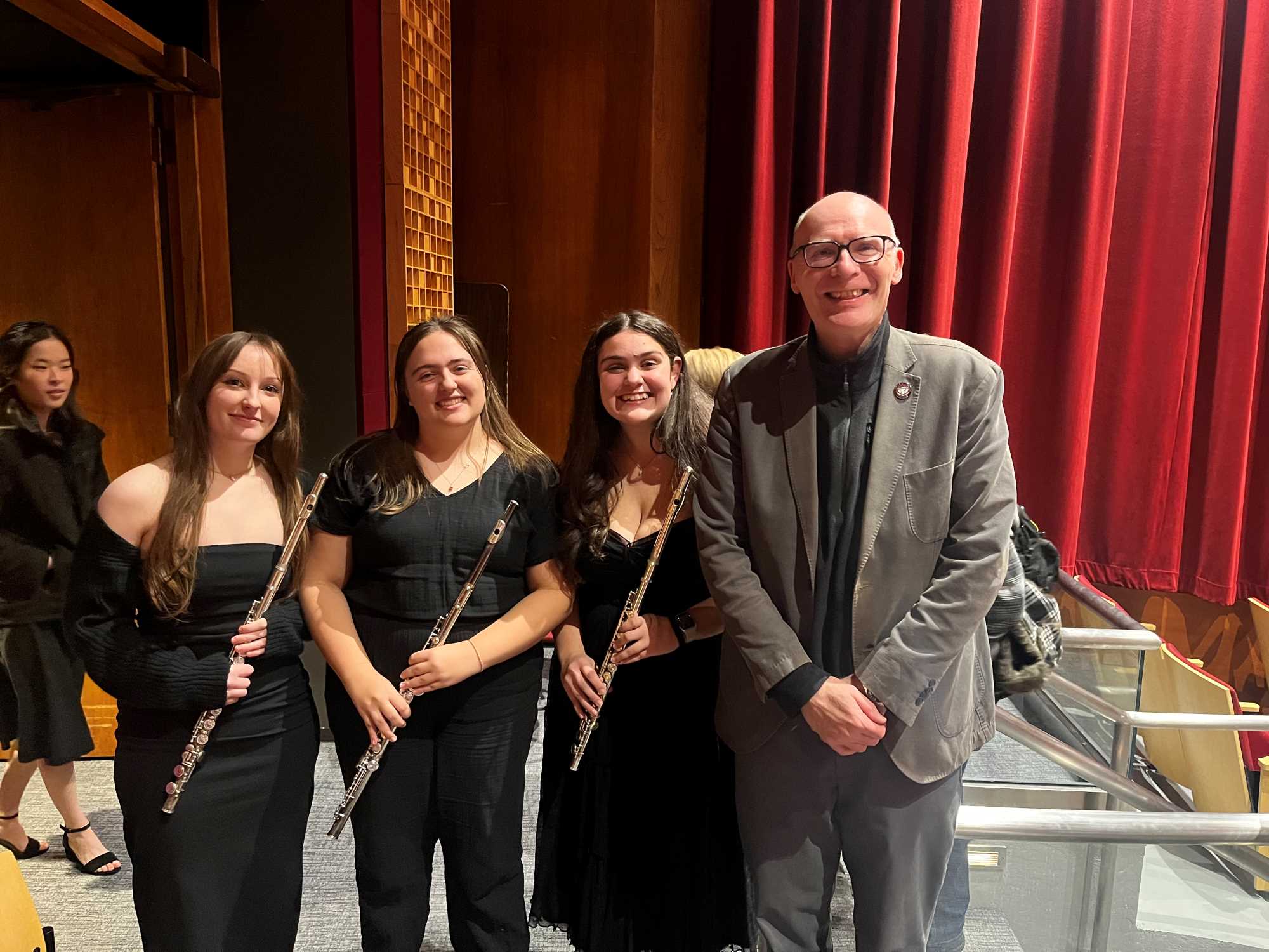 Chancellor Beeby posing for picture with 3 flutists at UWL band concert Spring 2026.