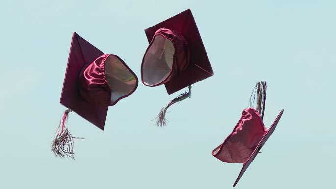 Graduation caps tossed in the air.