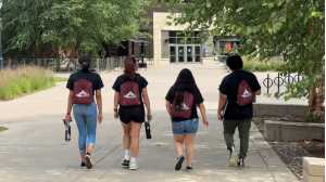 4 AERIE Peer Mentors walking down the sidewalk with matching AERIE LLC bags