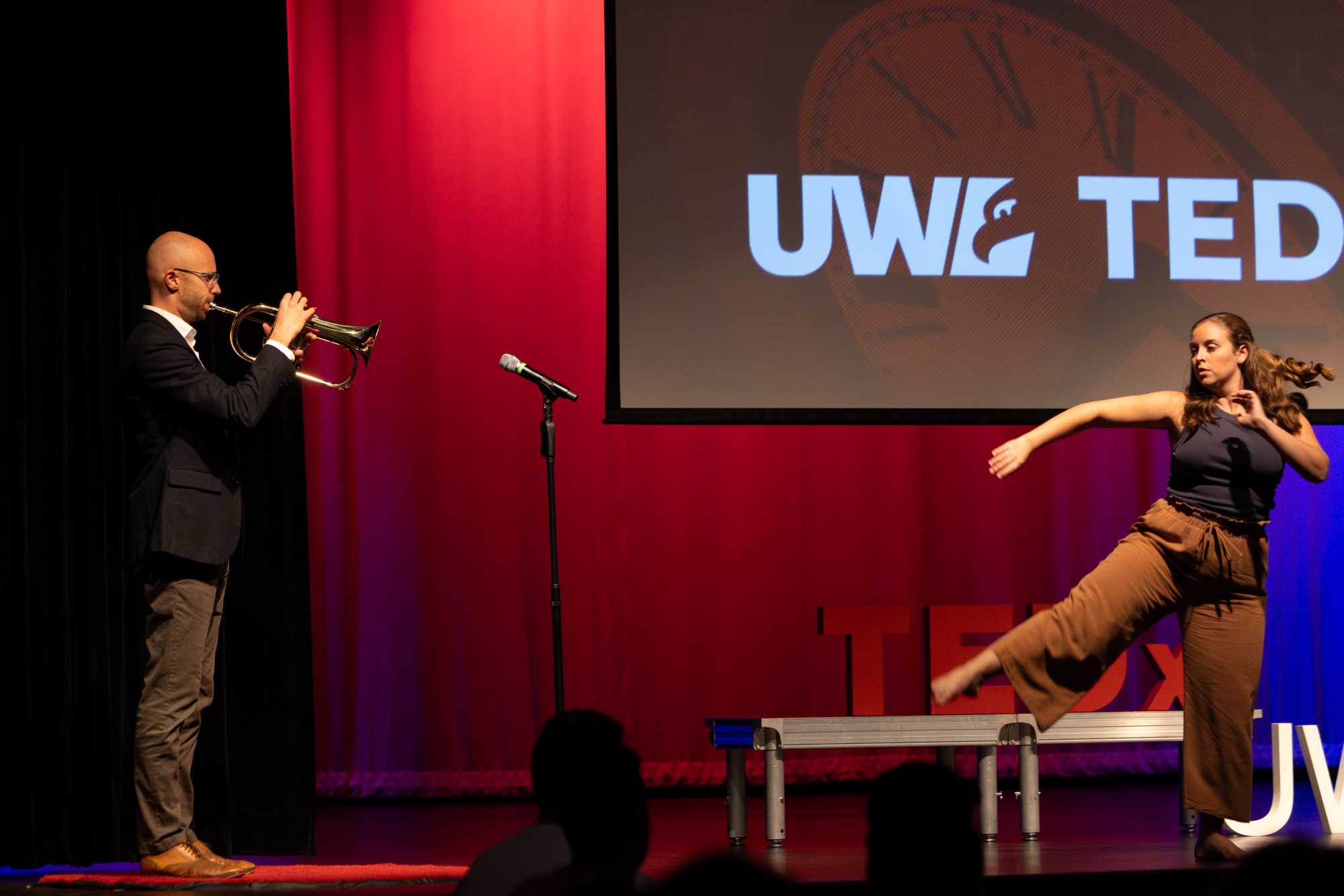 Between speakers Jon Ailabouni, UWL assistant teaching professor of Music, and  Ashley Dobrogosz, assistant professor of dance, entertain with a trumpet solo and dance.