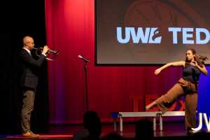 Between speakers Jon Ailabouni, UWL assistant teaching professor of Music, and  Ashley Dobrogosz, assistant professor of dance, entertain with a trumpet solo and dance.