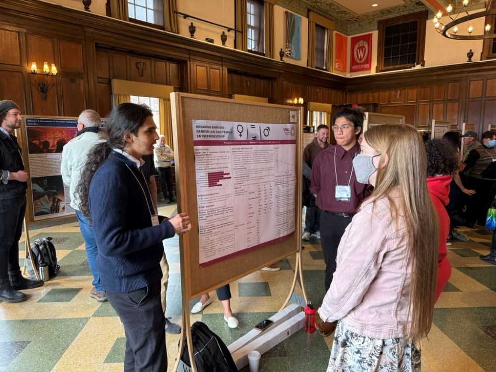 Two students present their research to onlookers