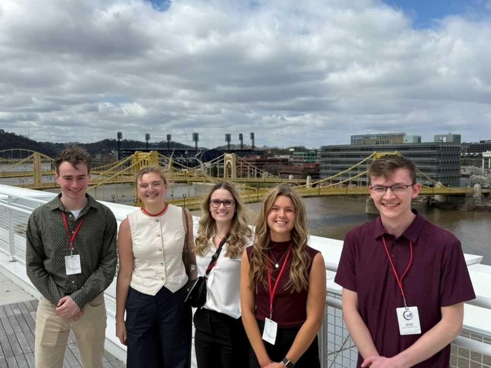 Five students stand on top of the convention center in Pittsburgh, PA.