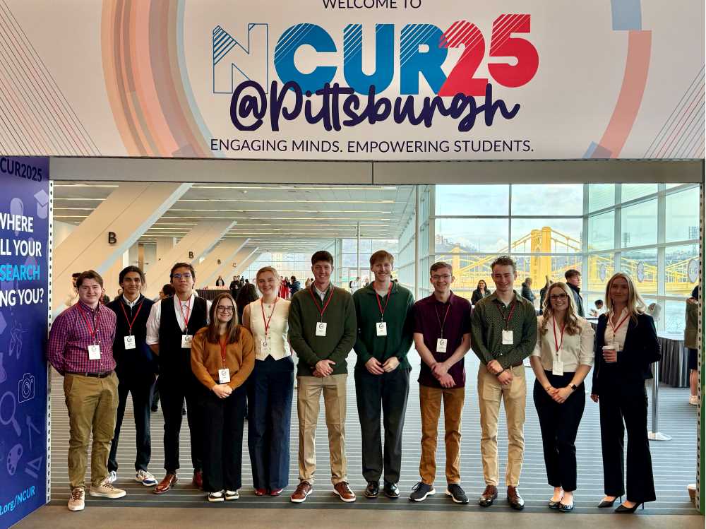 UWL students stand under a banner that reads "NCUR 2025 @Pittsburgh"